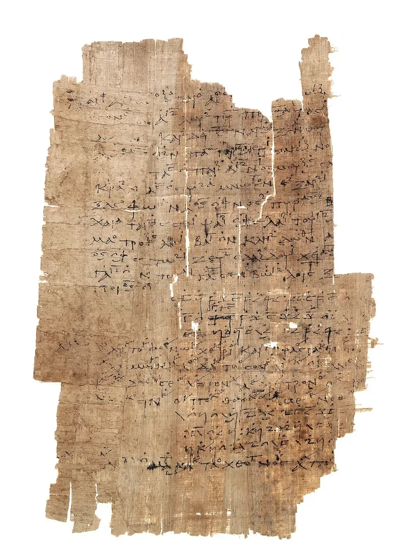 A ragged sheet of papyrus covered with lines of Greek writing, with small signs written above some of the lines.