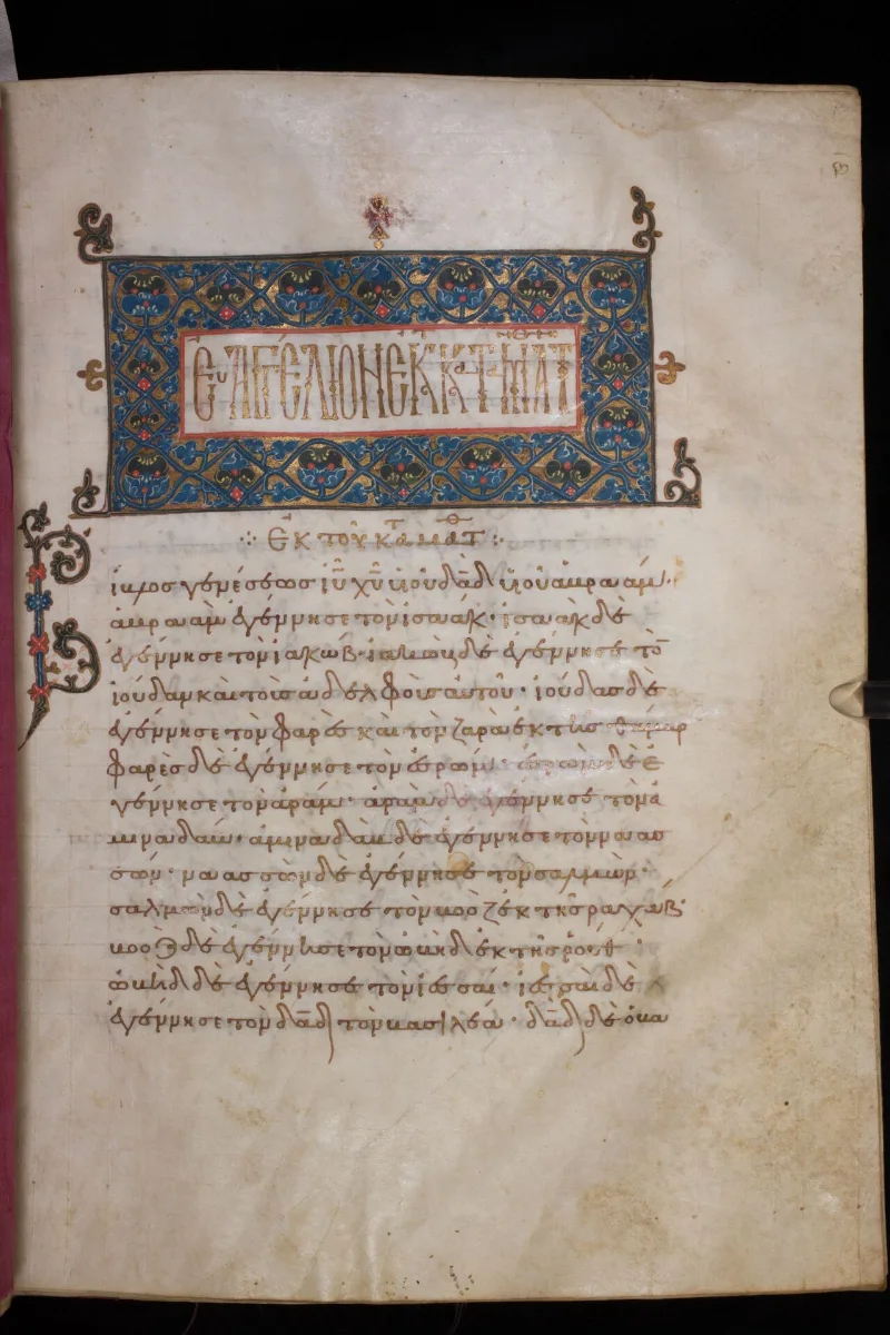 A parchment page with a gold and blue ornamental headpiece and a title in gold, above lines of Greek minuscule.