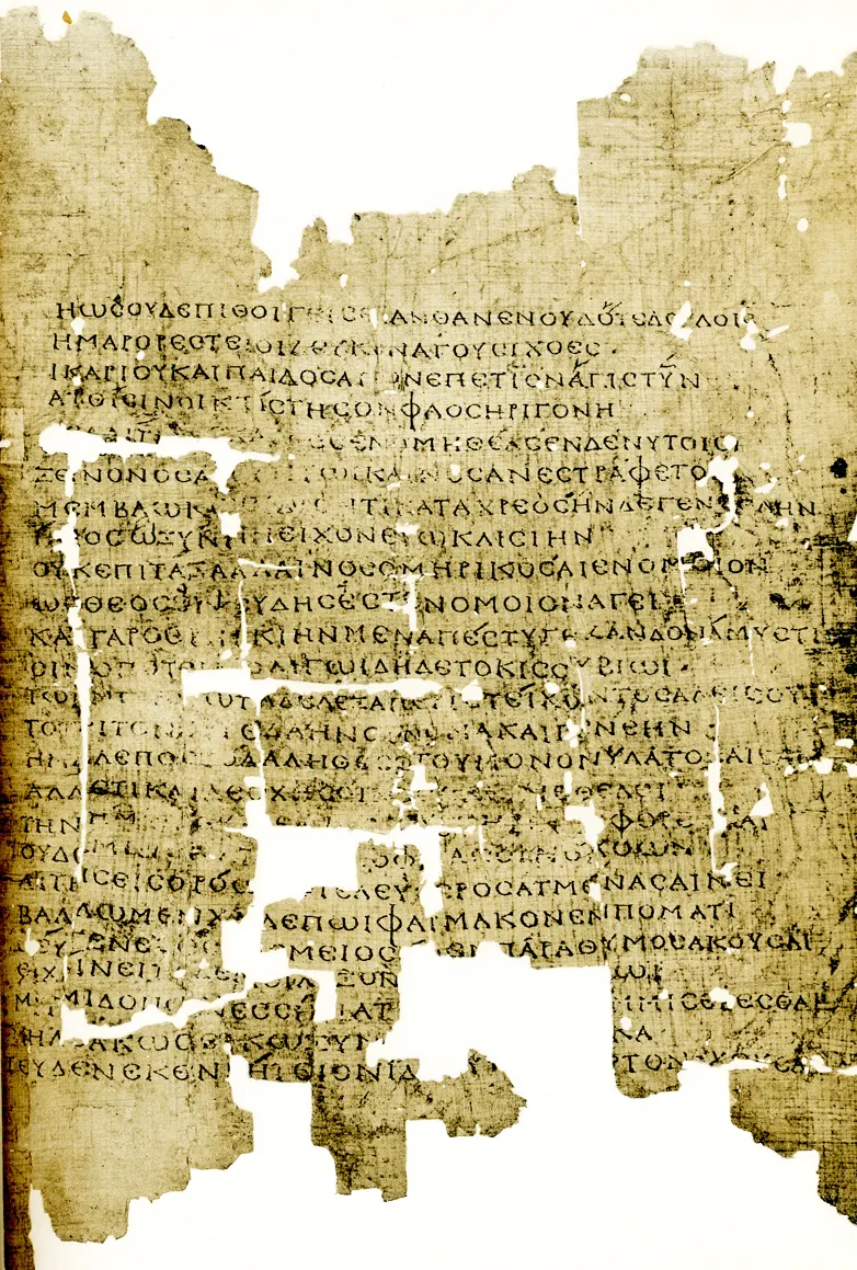 A tall brown papyrus fragment with a column of Greek capitals, its edges eaten away.