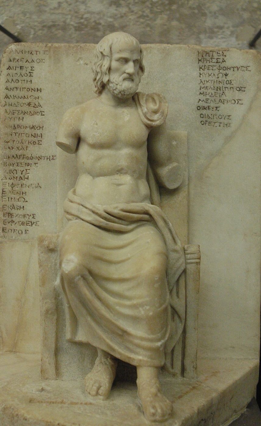 Marble statuette of a seated man; behind him a panel inscribed with columns of play titles.