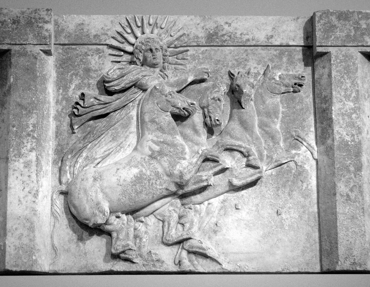 Marble relief: the sun god with a crown of rays drives four rearing horses.