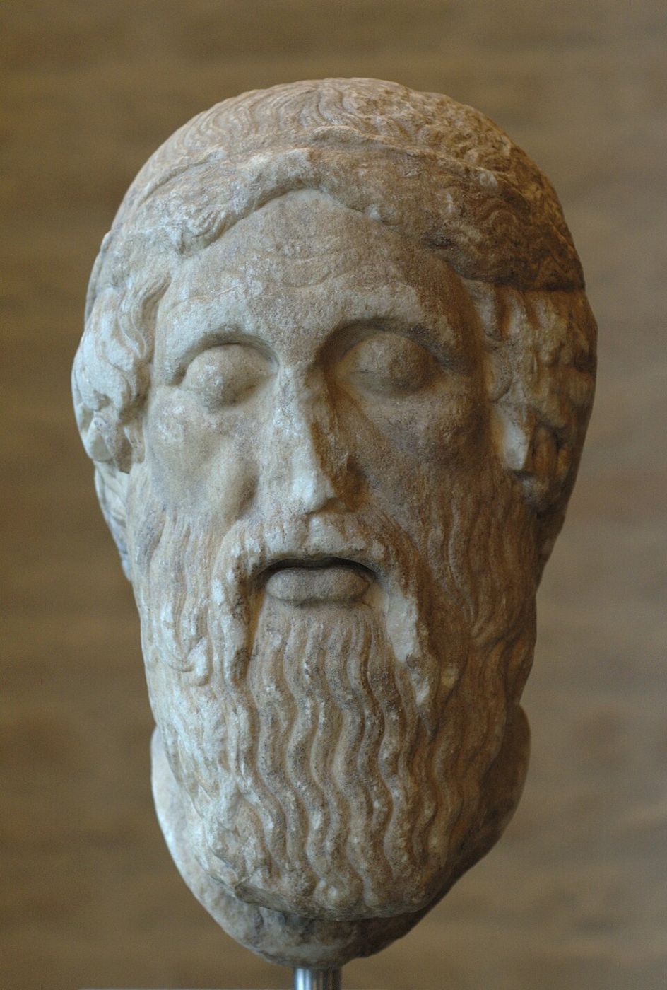 Marble head of a bearded man with closed eyes.