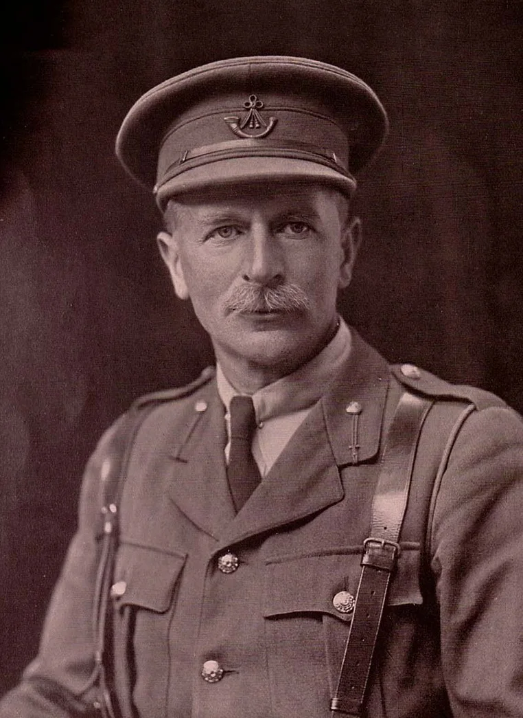 Photographic portrait of a man with a moustache in a dark suit and tie.