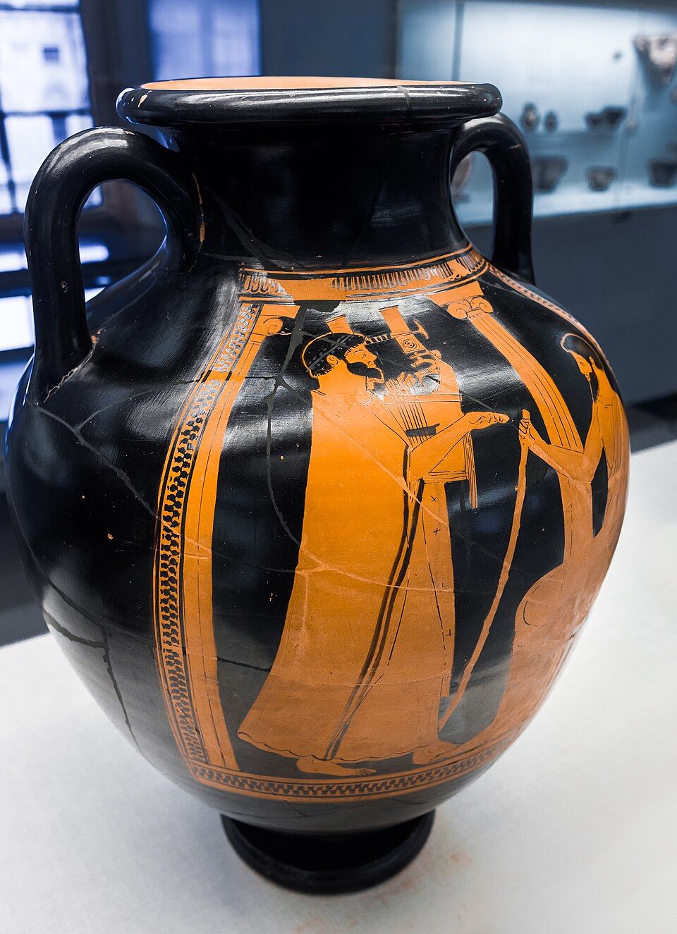 Red-figure amphora: a man in a long robe plays a large kithara before a seated man.