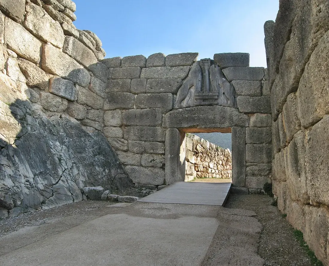 A massive stone gateway with a relief of two lions above the lintel.