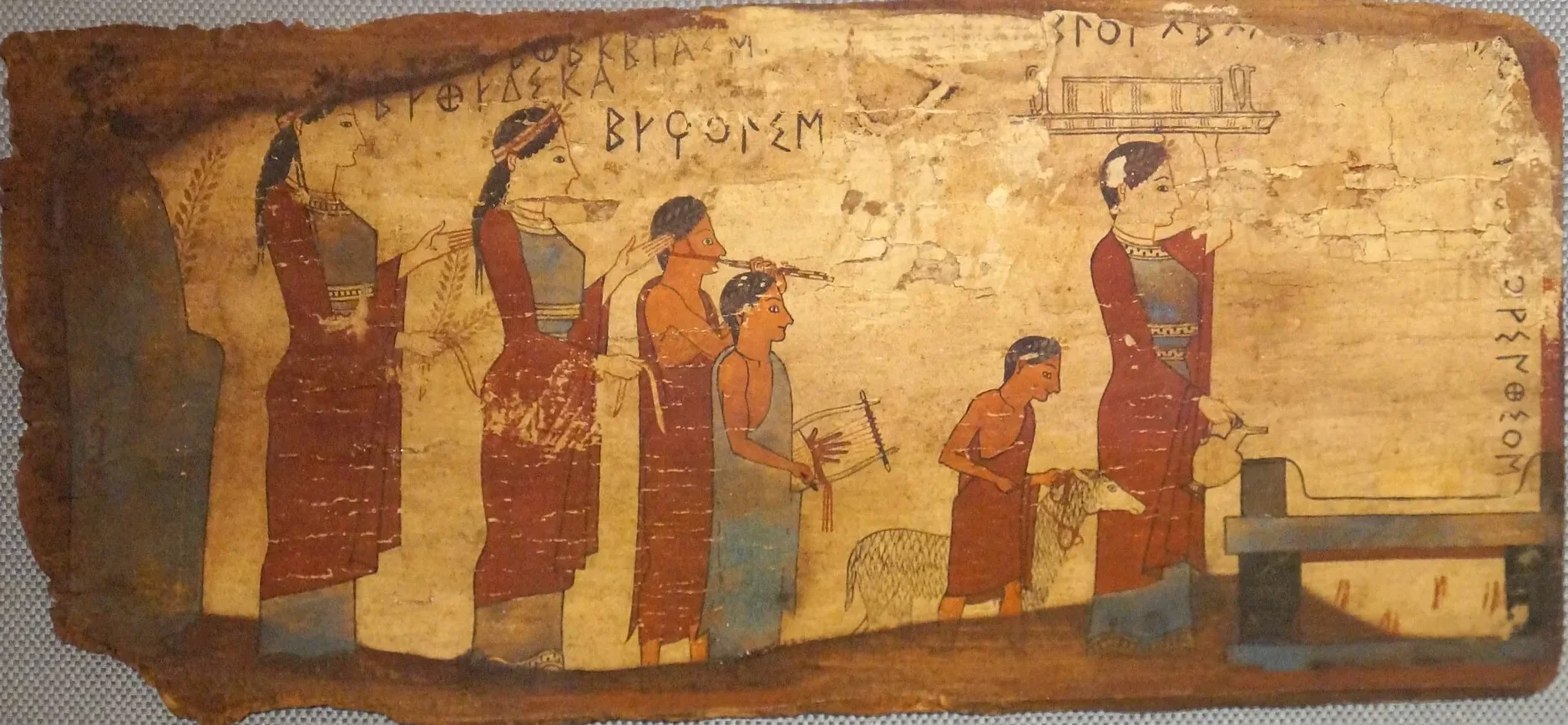 Painted wooden panel: women and boys walk in procession to an altar, one playing a double pipe and one a lyre, a boy leading a lamb; Greek names are painted above them.