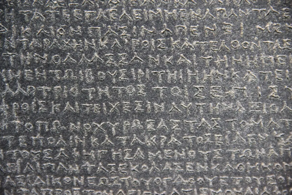 Close view of dark stone densely inscribed with small Greek capitals.