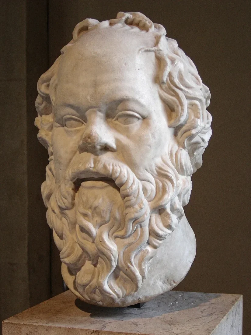 A marble portrait head of a bearded, snub-nosed man.