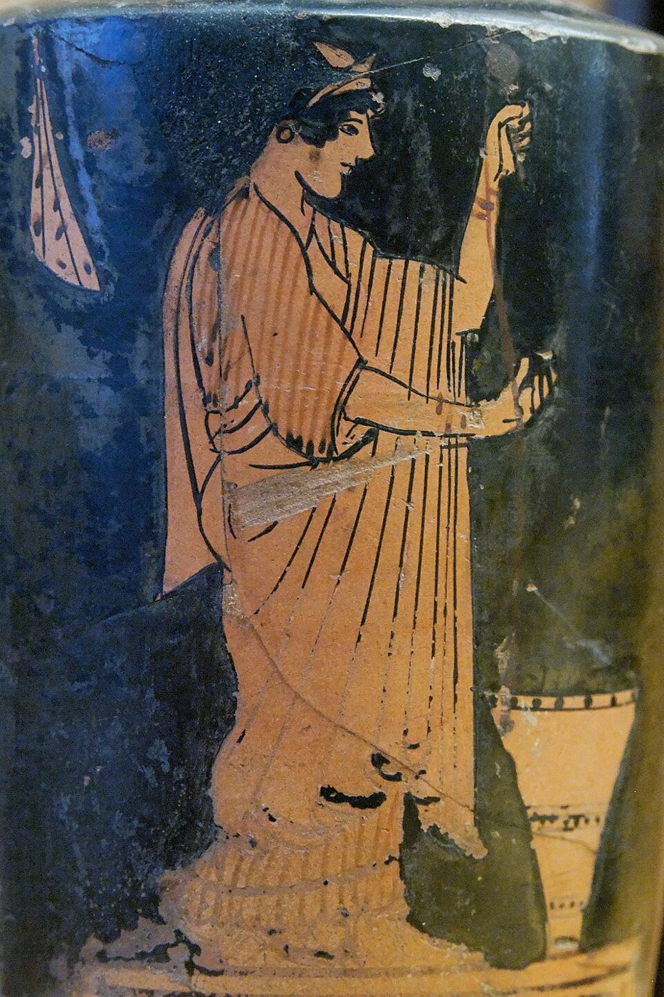 Red-figure oil flask: a standing woman spinning thread.